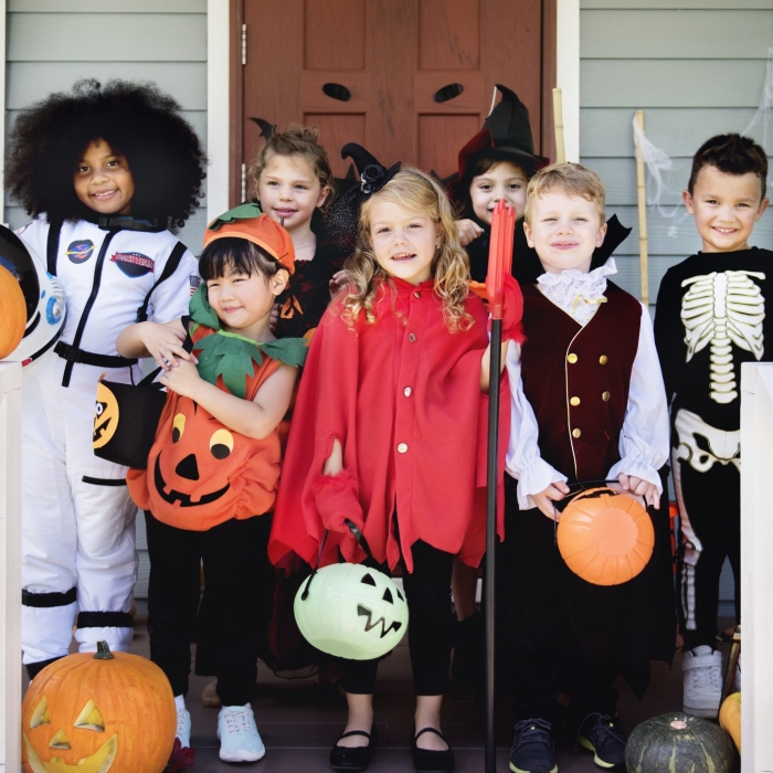 Kids in costumes with bright colors — choose safe, visible costumes for trick-or-treating.